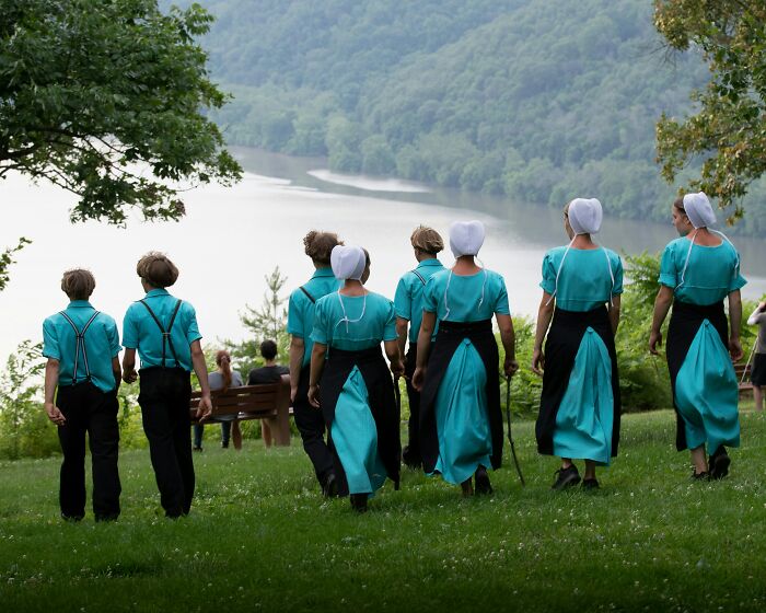 People in traditional attire walking toward a scenic lake, evoking themes of awkward and unhinged delivery stories.