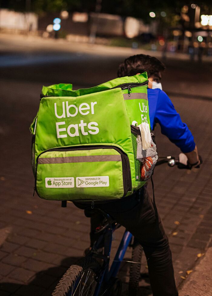 Uber Eats delivery on a bike at night, highlighting an awkward delivery moment.