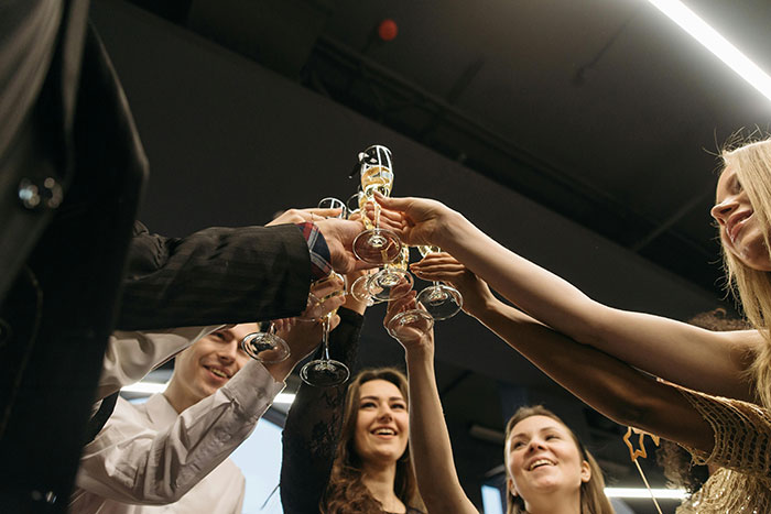 People toasting with champagne glasses at a celebration, smiling and enjoying the moment together.