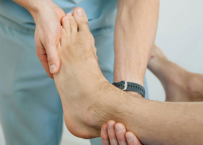 A doctor examining a patient's foot in a healthcare setting.