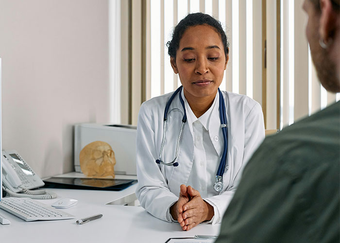 Doctor in a white coat consulting a patient, highlighting American healthcare challenges.