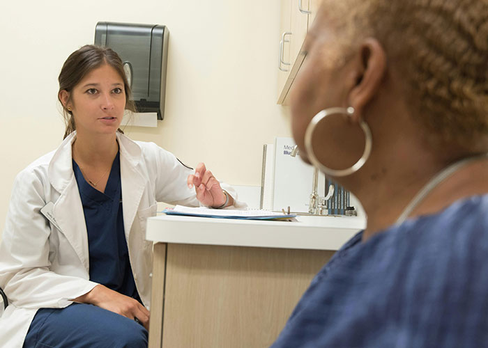 Doctor consulting patient in clinic, highlighting American healthcare issues.