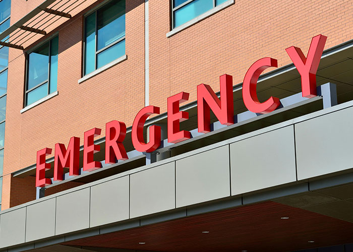 Emergency entrance sign at a hospital, highlighting American healthcare challenges.