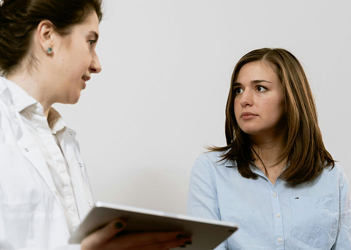 Healthcare professional discussing with a concerned patient, highlighting American healthcare challenges.