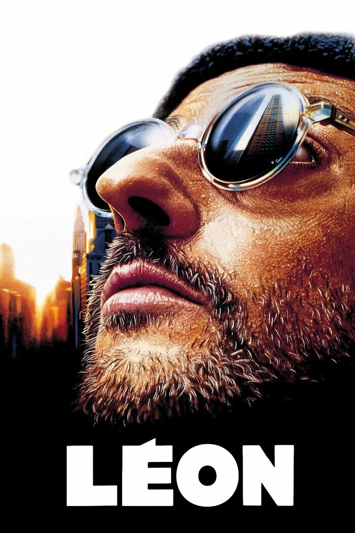 Close-up of a man's face with sunglasses reflecting a skyscraper, reminiscent of Best Nostalgia Movies.