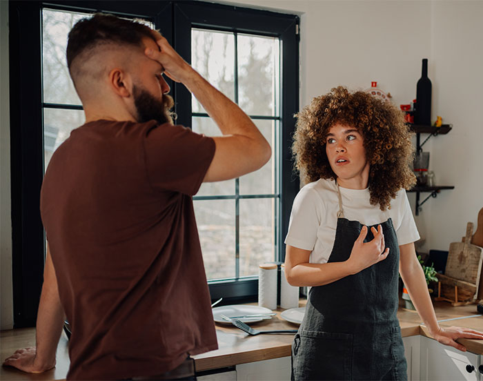 Man and woman in a kitchen having a tense conversation about brain rot speak.