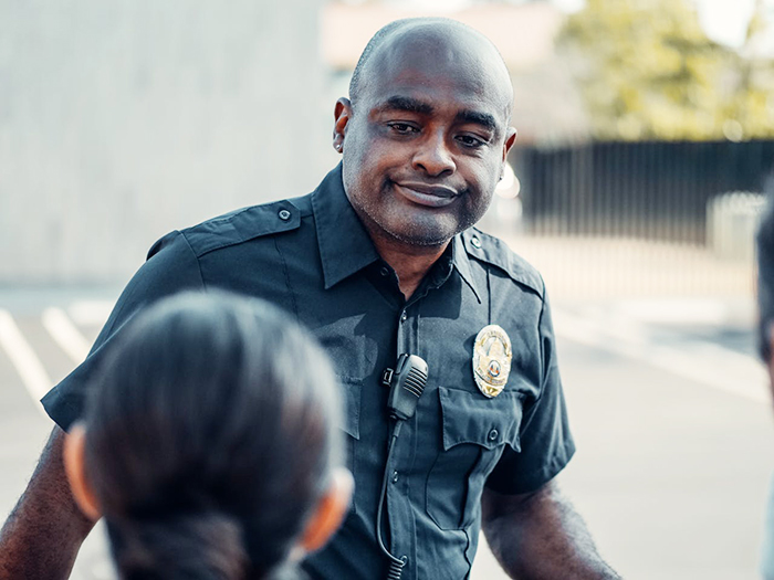 Officer talking to a woman outdoors, related to CPS call over toddler tantrums.