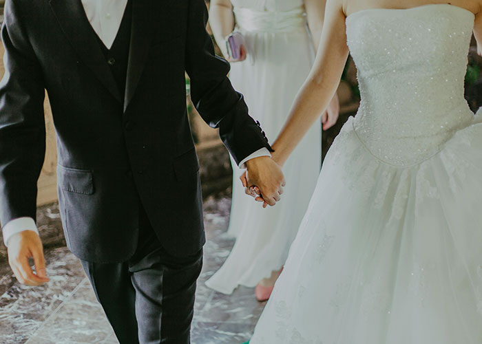 Bride and groom holding hands in wedding attire, symbolizing eloping.