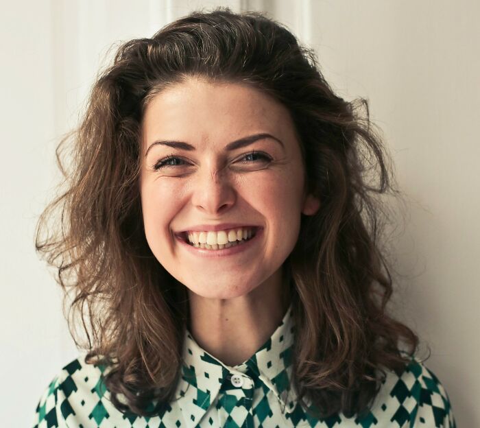 Smiling woman indoors, representing socializing which may lose appeal for older adults.