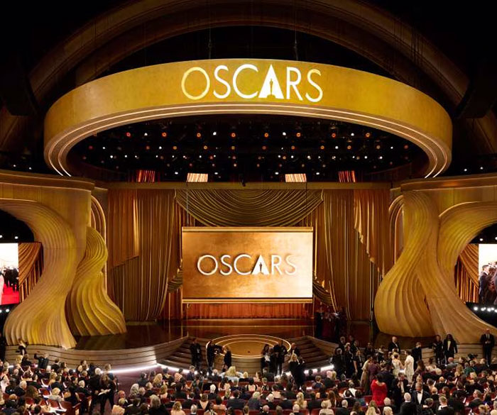 Oscar nominees 2025 event, golden stage design, large audience gathered in a grand theater setting.