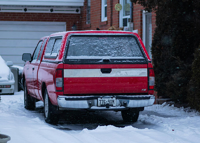 Red truck parked on snowy driveway, relevant to a story about a mom with dementia facing issues with couple.