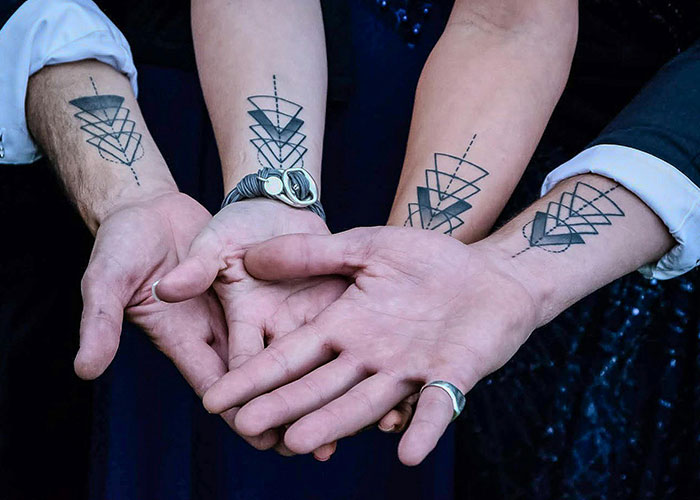 Three people displaying similar geometric tattoos on their arms, symbolizing the importance of frontal lobe awareness before getting inked.