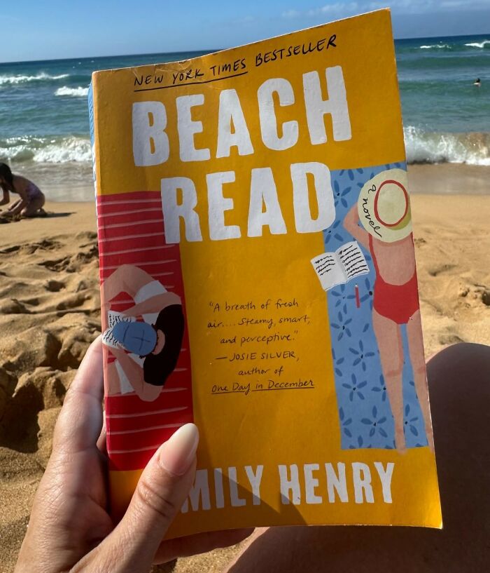 Person holding "Beach Read" book at a sunny beach, showcasing one of the most romantic books of all time.