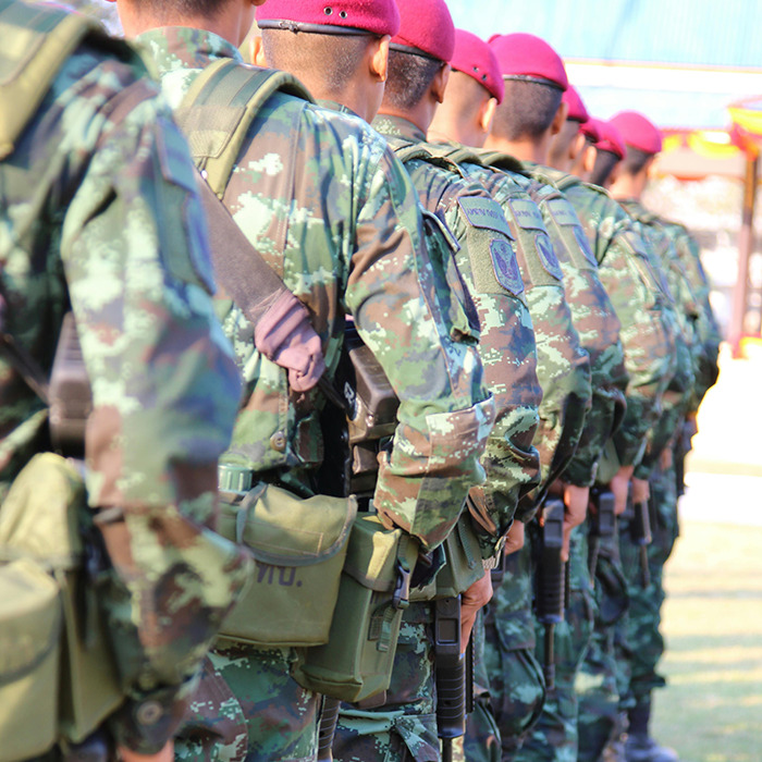 Soldiers in camouflage uniforms standing in formation at a military base.