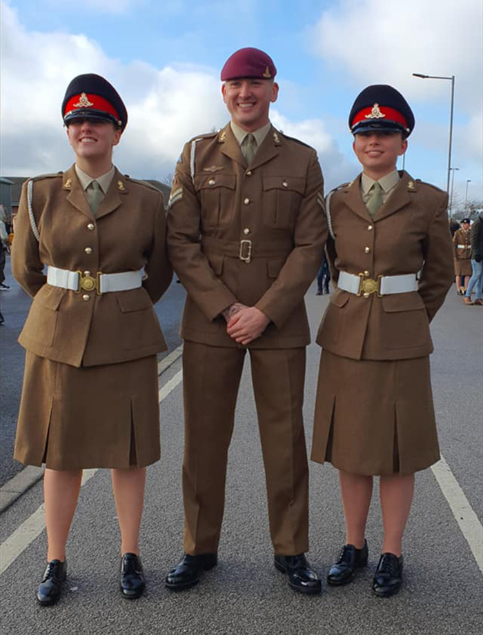 Three soldiers in brown uniforms, posing outdoors.