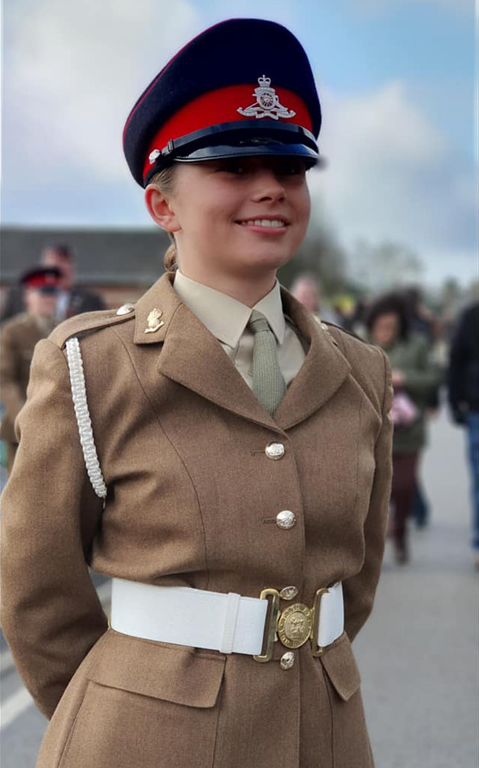 Young soldier in uniform smiling at a military base event.