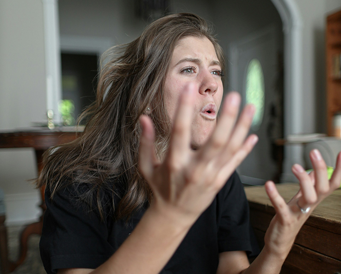 Woman passionately talking, gesturing with her hands, indoors.