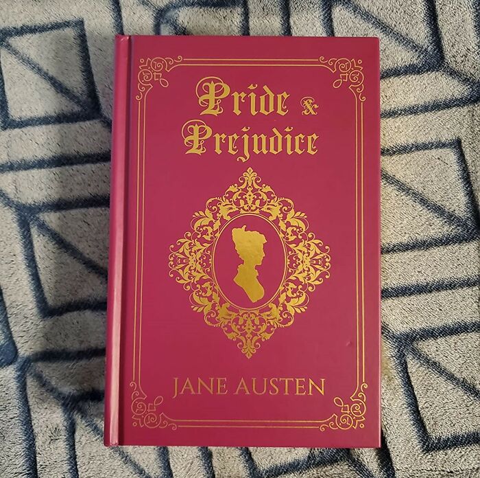 Romantic book "Pride and Prejudice" with an ornate red and gold cover, featuring a silhouette design.