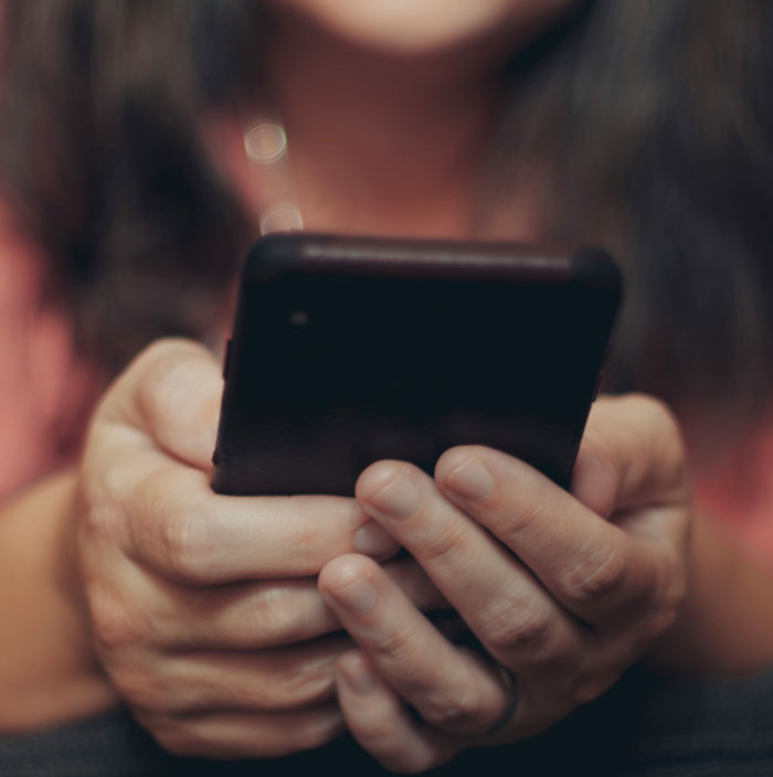 Hands holding a smartphone, possibly texting about being left home alone.