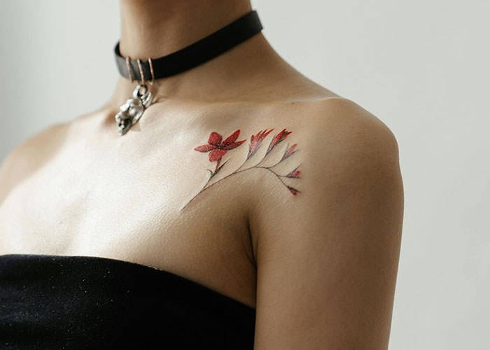 A delicate floral tattoo on a person's shoulder, highlighting something to consider before getting inked.