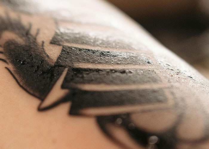 Close-up of a fresh tattoo with detailed ink lines on skin.