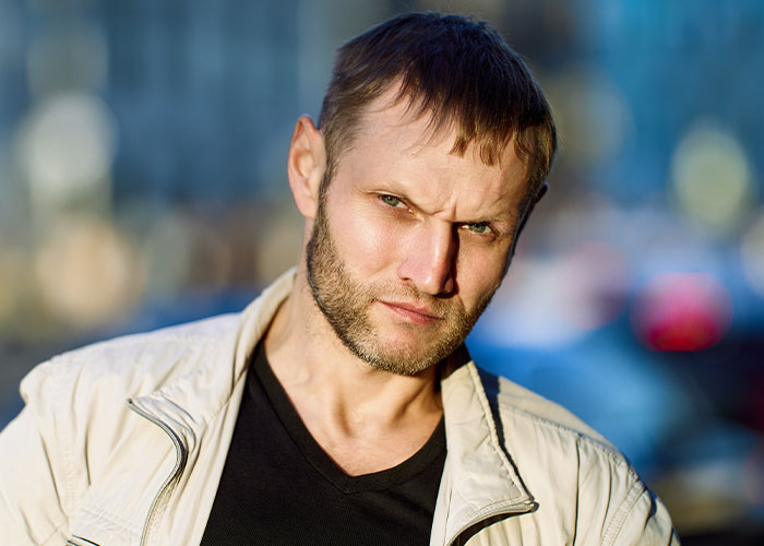 A man outdoors in a light jacket, blurred background; related to a yard sale and police intervention.