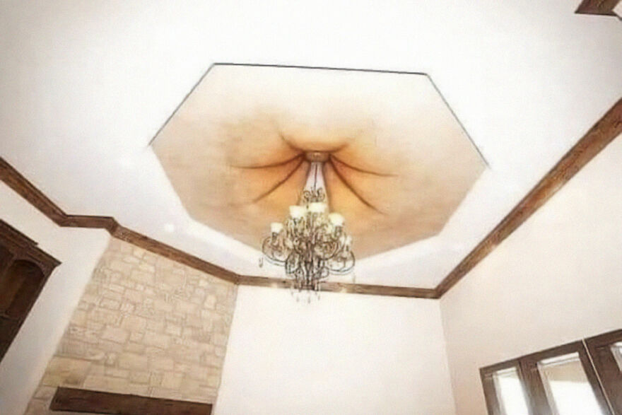 Chandelier hanging from a ceiling with unusual architecture design, showcasing architecture shaming aspects.