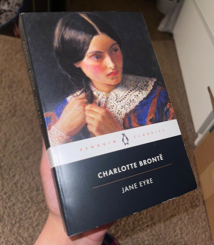 Cover of "Jane Eyre" by Charlotte Brontë, a classic romantic book, held by a hand.