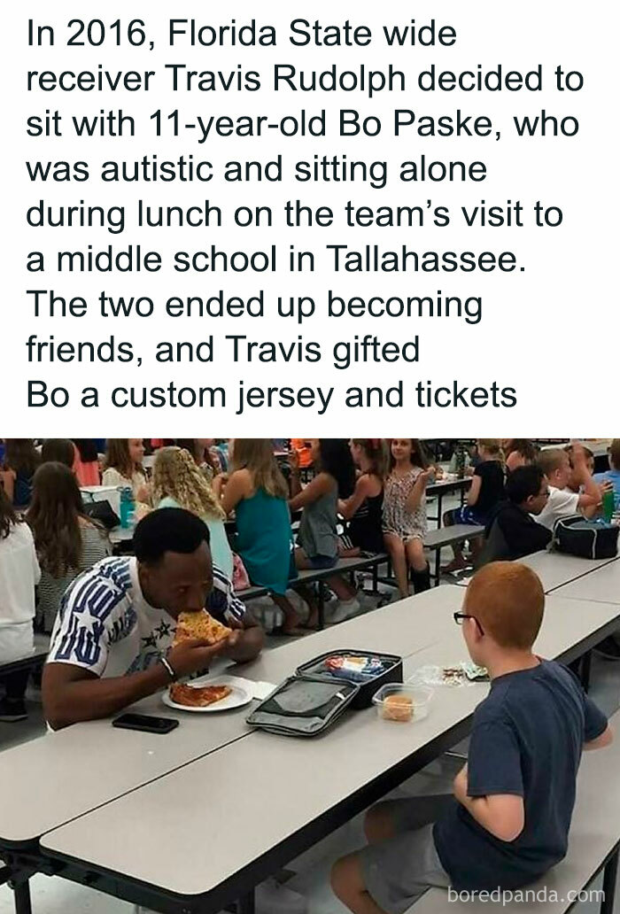 Athlete sharing lunch with a young boy in a school cafeteria, illustrating a heartwarming moment of friendship and joy.