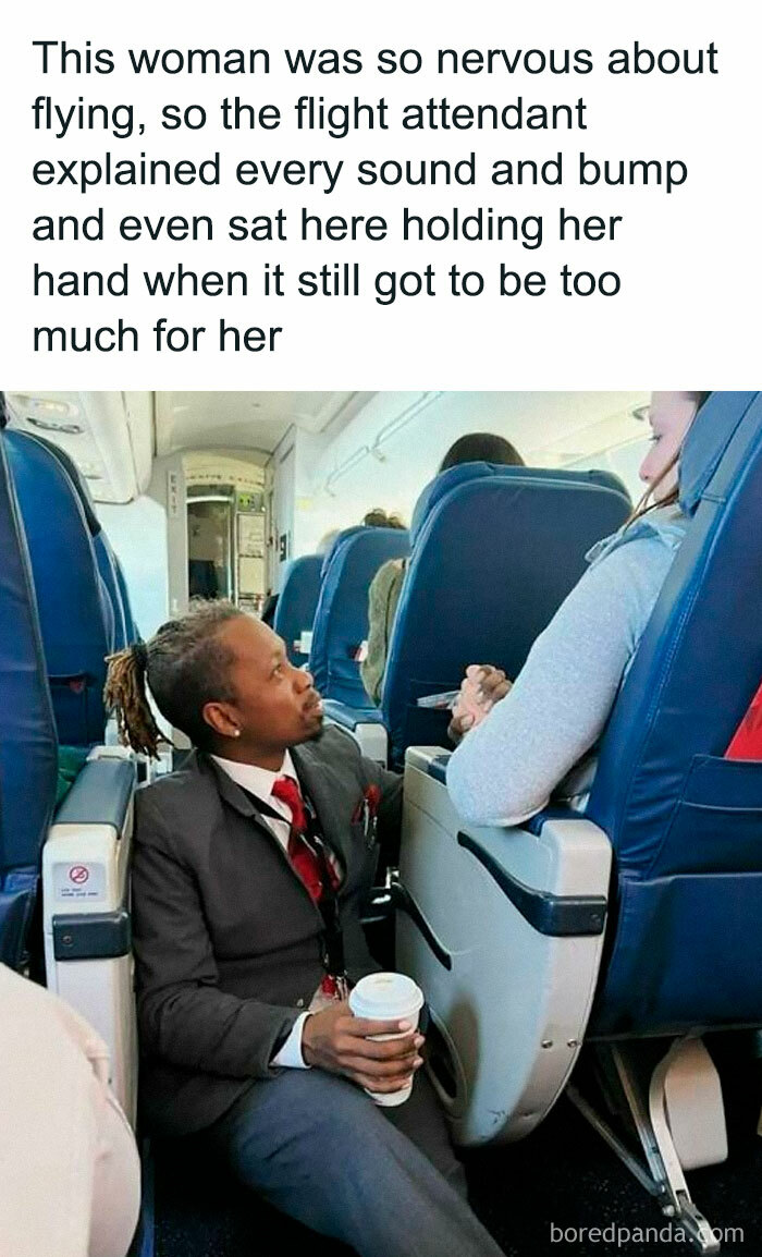 Flight attendant comforts a passenger by holding her hand, creating a heartwarming moment on the plane.