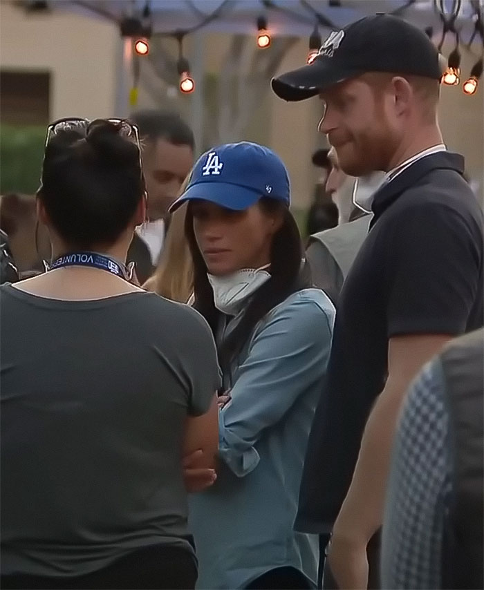 People at an outdoor event, wearing caps and casual clothing, socializing in a relaxed atmosphere.