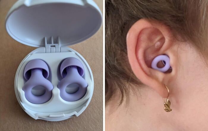 Purple earplugs in a white case and worn in an ear.