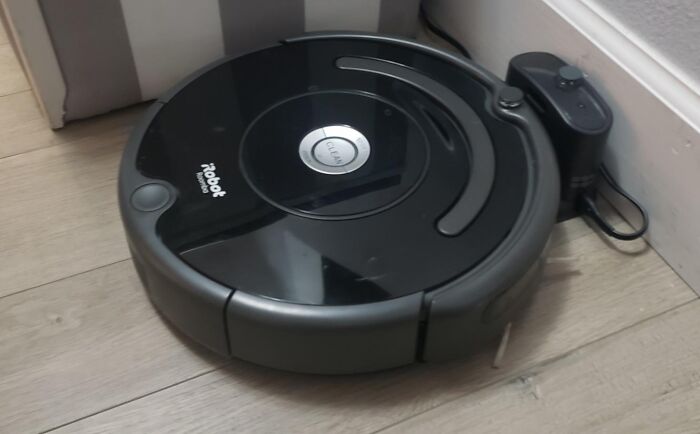 Robot vacuum cleaner on a hardwood floor, showcasing a smart home investment worth spending money on.