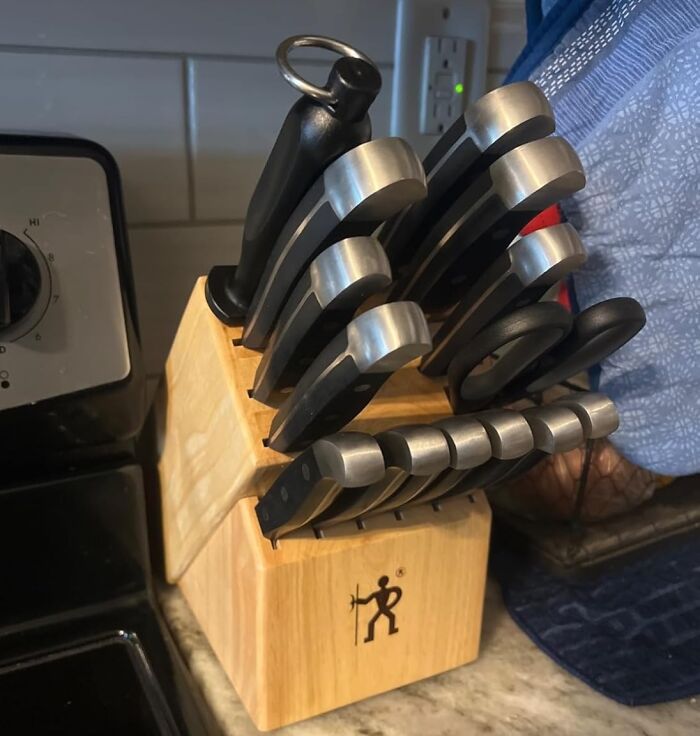 Knife set in a wooden block on a kitchen counter, showcasing things worth spending money on for quality cooking tools.