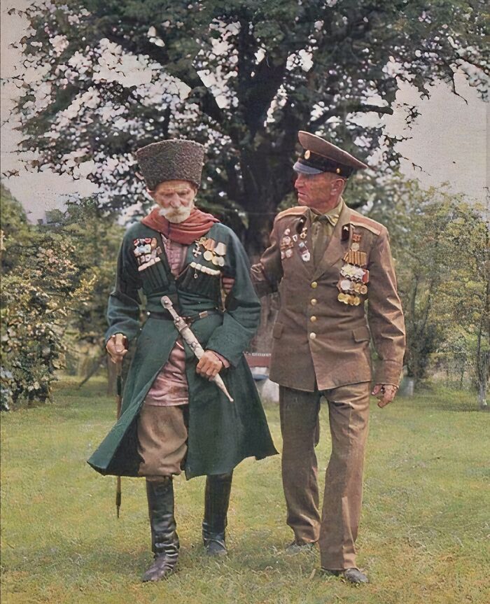 Two decorated military veterans in uniform walking together, representing a rare historical moment.