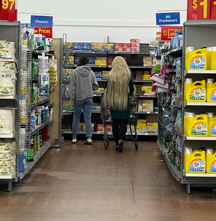 Person with very long hair shopping in a store aisle, demonstrating a hair fail.