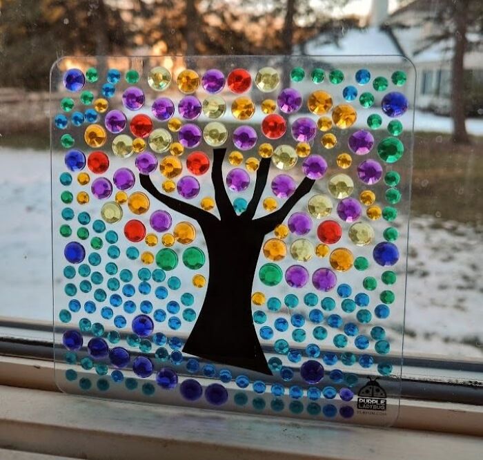 Colorful gem tree craft for Valentine's Day gifts kids love, displayed on a window with a snowy background.