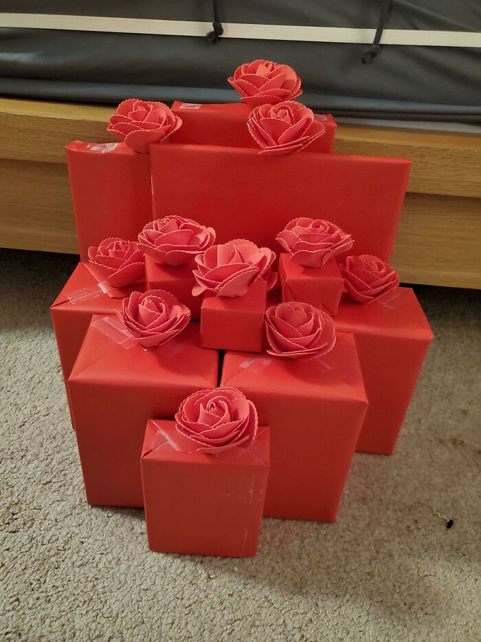 Red gifts with rose toppers on a carpet, perfect Valentine’s Day inspiration.