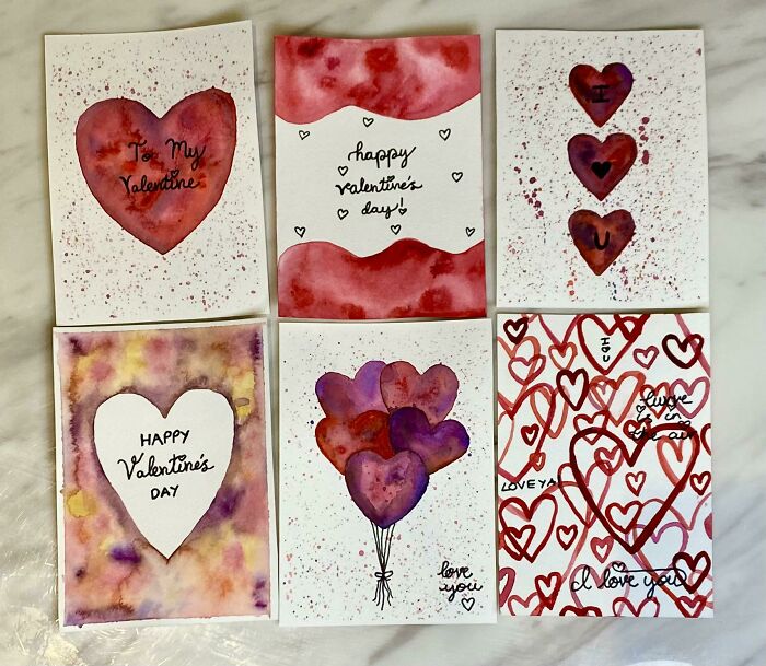 Valentine's Day-themed hand-painted cards featuring hearts and love messages.