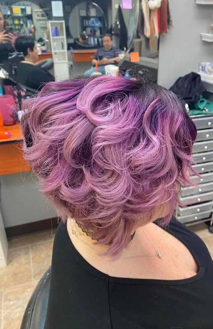 Purple curly hair fail in a salon, highlighting uneven style and mismatched shading for worst hair fails keyword.