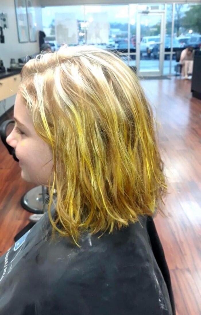 Yellow-tinged hair fail in a salon, showing uneven dye job.