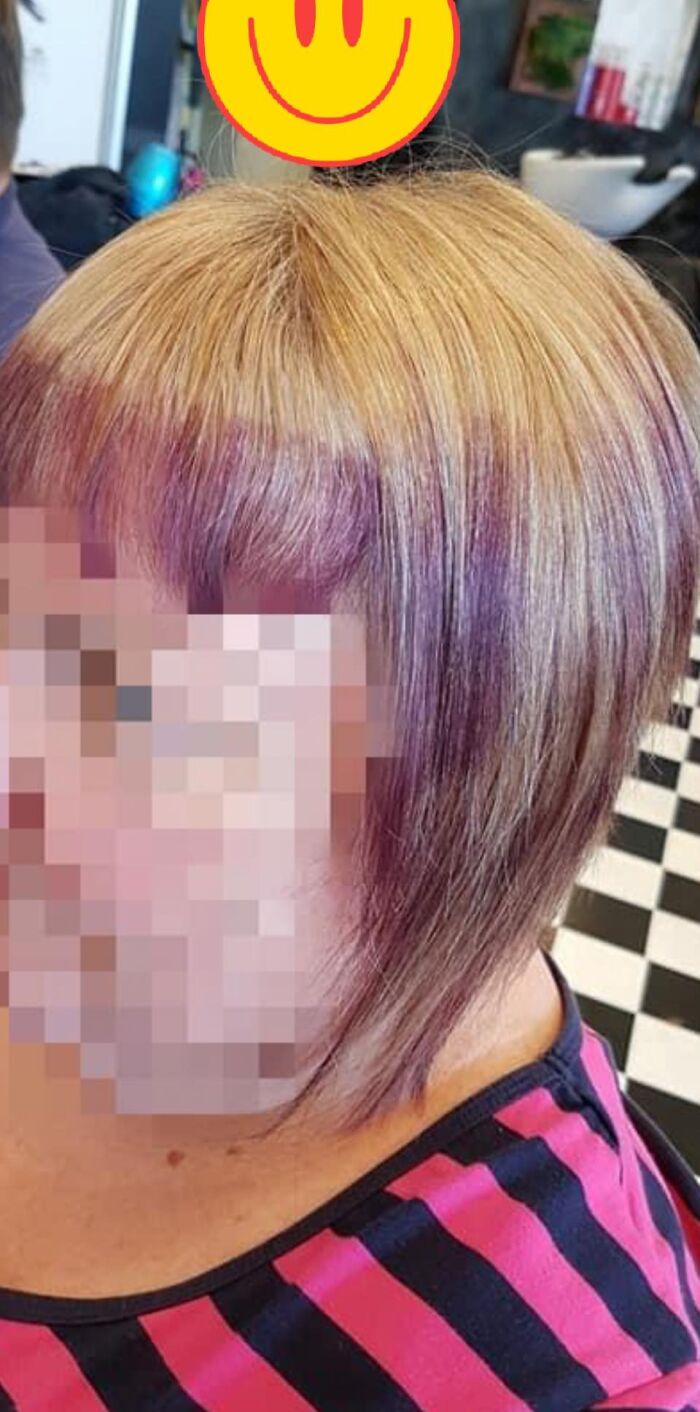 A woman with a short, uneven haircut and purple highlights, illustrating a hair fail.