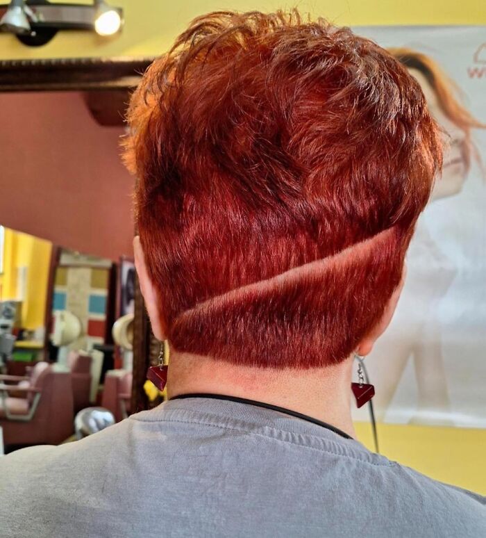 Back view of a haircut with uneven red hair and a diagonal line, showcasing a hair fail.