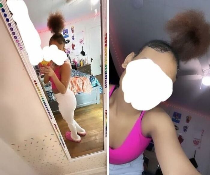 Person with a hair fail wearing a pink top, taking a selfie in front of a mirror in a bedroom.