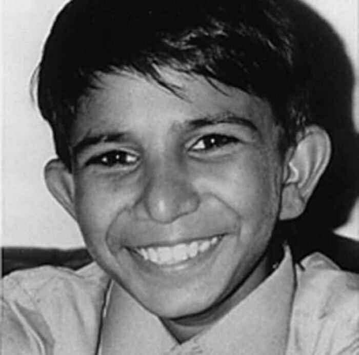 Smiling boy in a black and white photo, related to interesting facts.