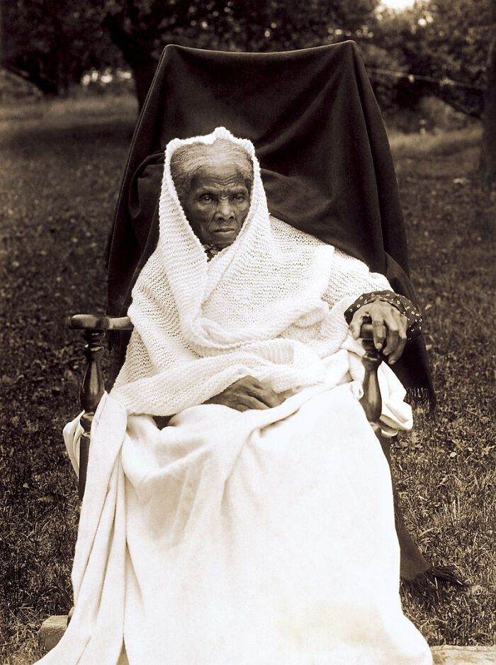 Elderly person in a shawl sitting outdoors, illustrating interesting historical facts.