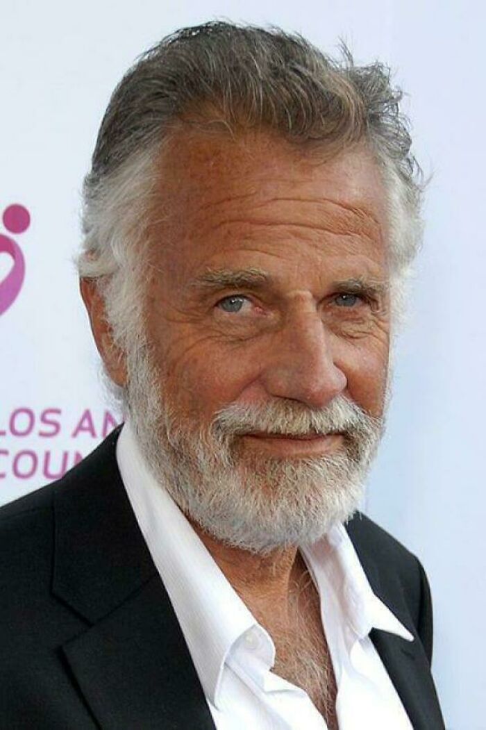 Man with gray beard and hair in a suit, smiling at an event; representing interesting facts shared by people.