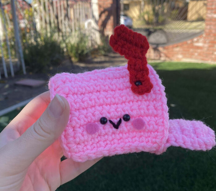 Cute knitted pink mailbox with a smiling face, perfect Valentine's Day gift inspiration.