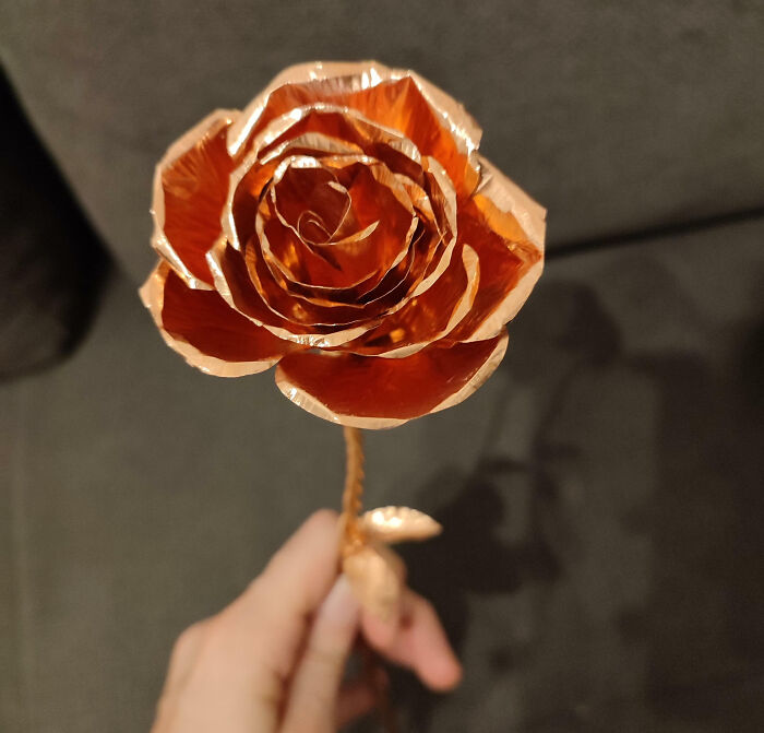 A hand holding a metallic rose, perfect inspiration for Valentine’s Day gifts.