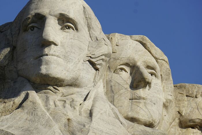 Close-up of Mount Rushmore with two presidents' faces, representing iconic mic-drop moments in history.